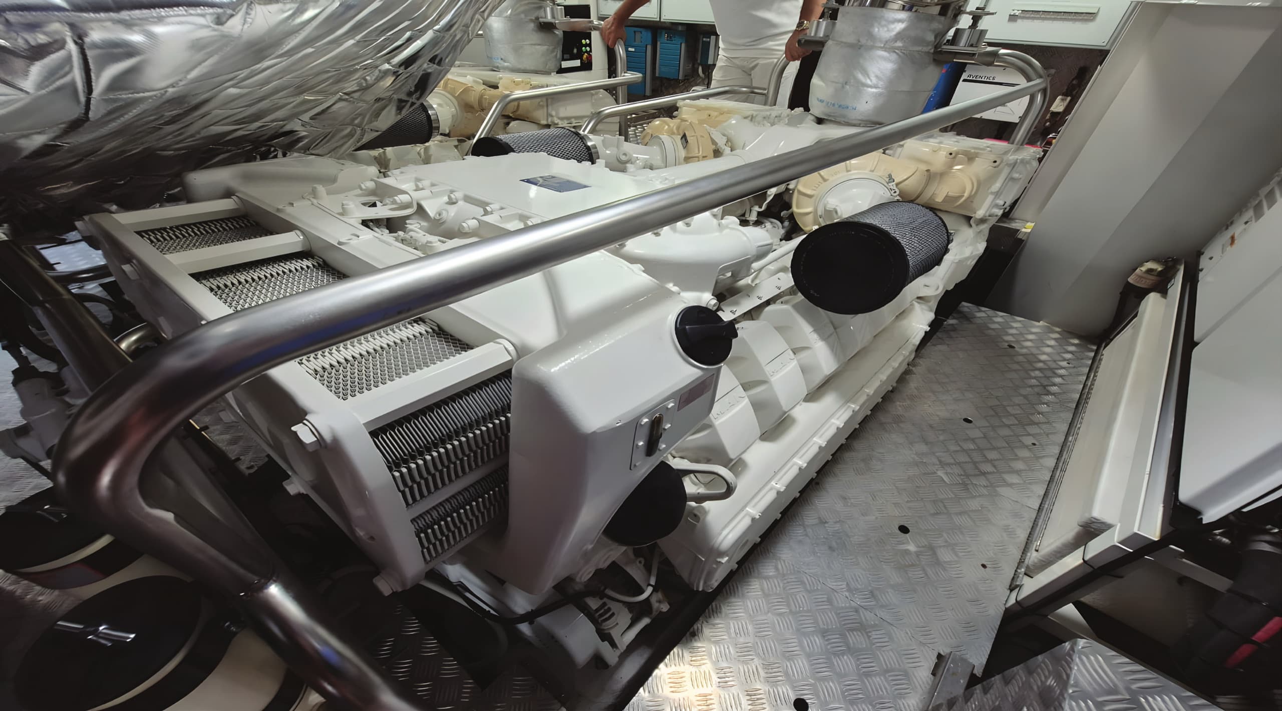 A white marine diesel engine in a serviced yacht engine room